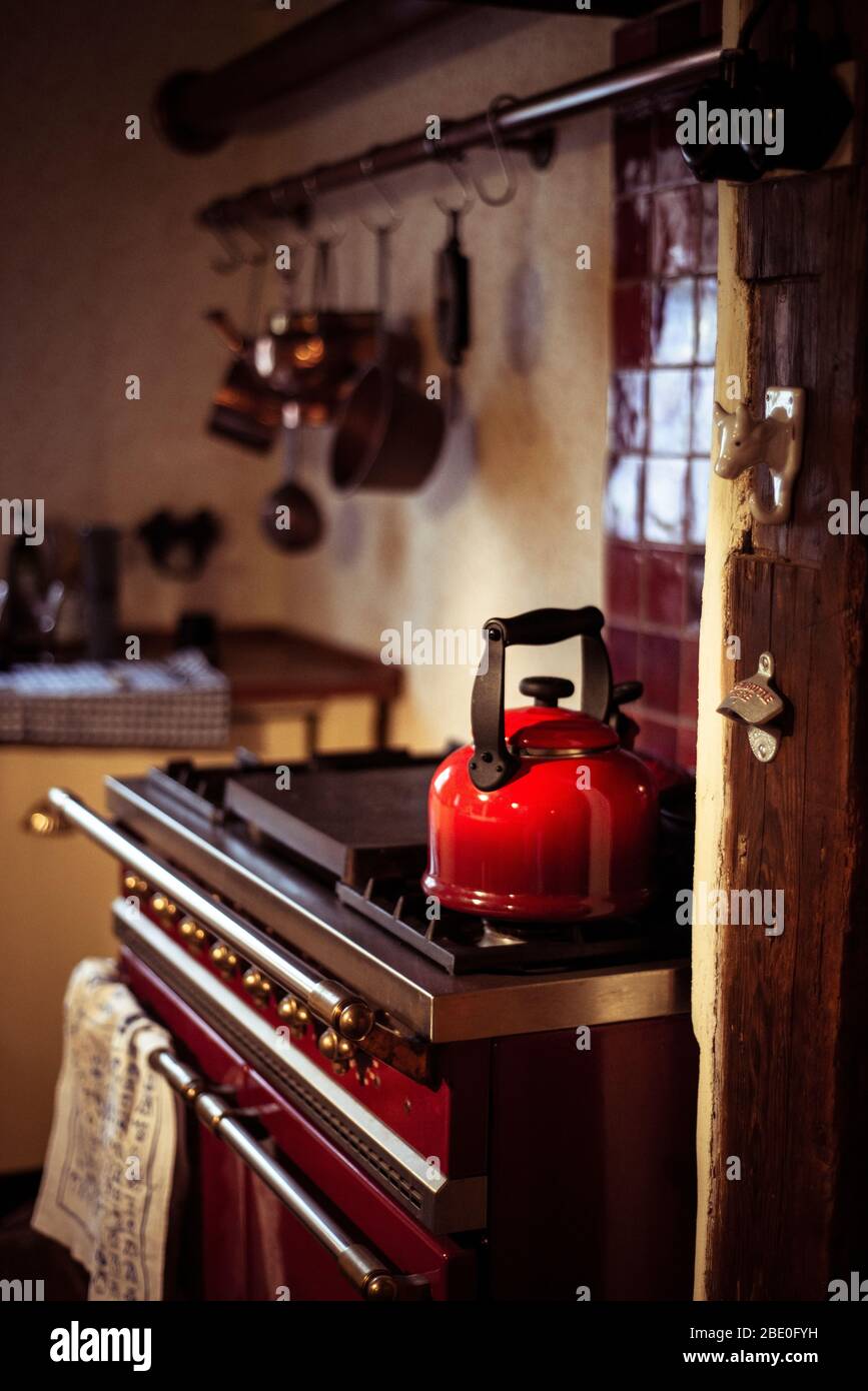 accogliente vecchia cucina tradizionale cottage con bollitore rosso e pentole Foto Stock
