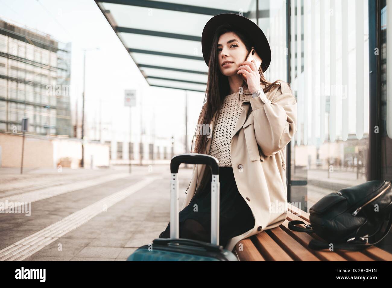 Ragazza elegante vestita con un cappotto e un cappello che parla al telefono Foto Stock