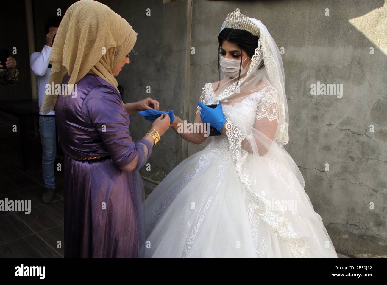 200410) -- KIRKUK (IRAQ), 10 aprile 2020 (Xinhua) -- la sposa Nourhan è  aiutata con i guanti nella paura del COVID-19 durante il suo matrimonio a  Kirkuk, Iraq, il 10 aprile 2020.