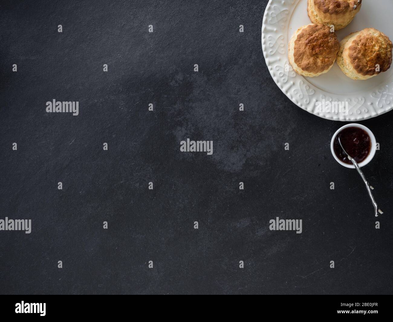 Focaccine fatte in casa appena sfornate con marmellata, sfondo di ardesia, vista dall'alto Foto Stock