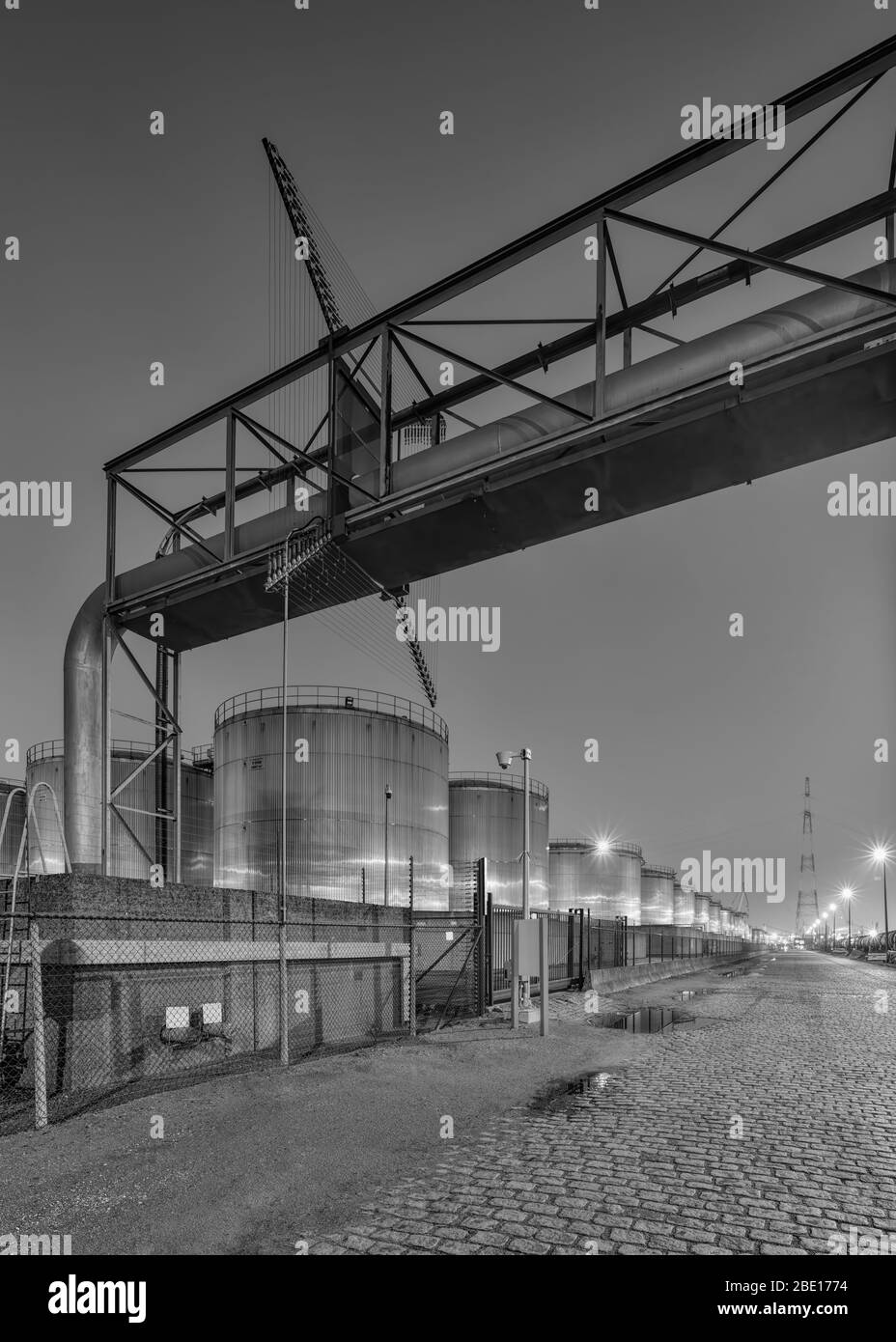 Scena notturna con grande silo e superamento di pipeline presso lo stabilimento di produzione petrolchimica, Porto di Anversa. Foto Stock