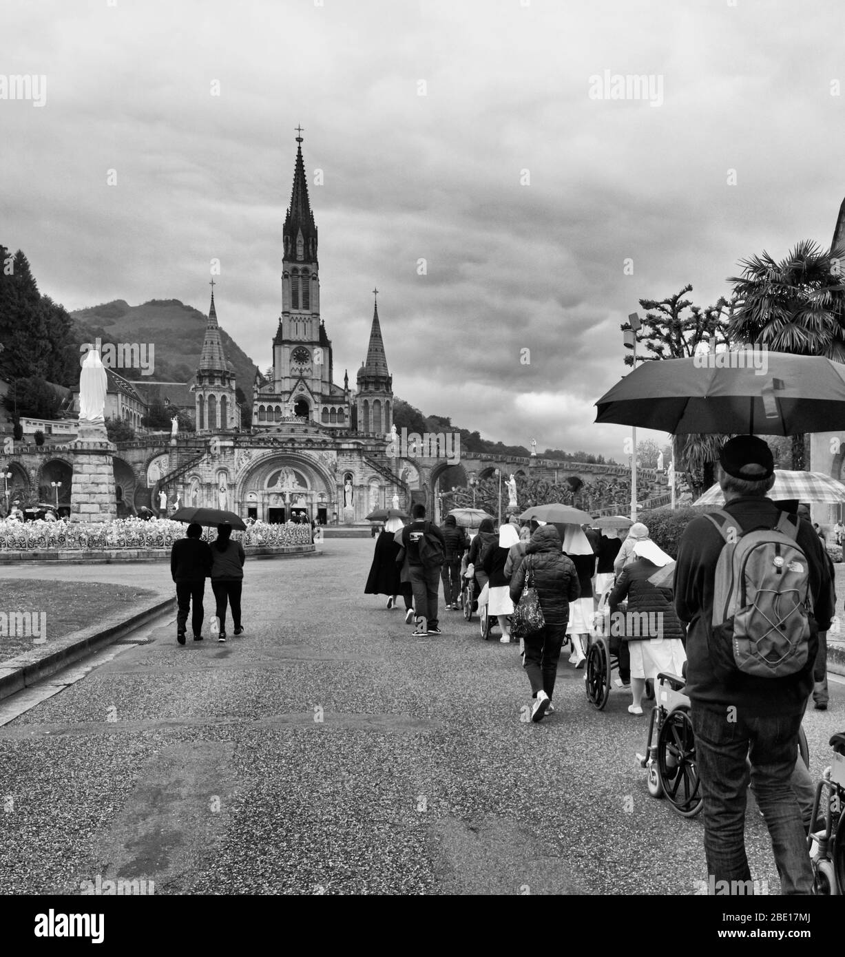 Persone in carrozzina che sono a ruote al Santuario di nostra Signora di Lourdes nella speranza di sollievo o la cura dei loro disturbi, Lourdes, alti Pirenei Foto Stock