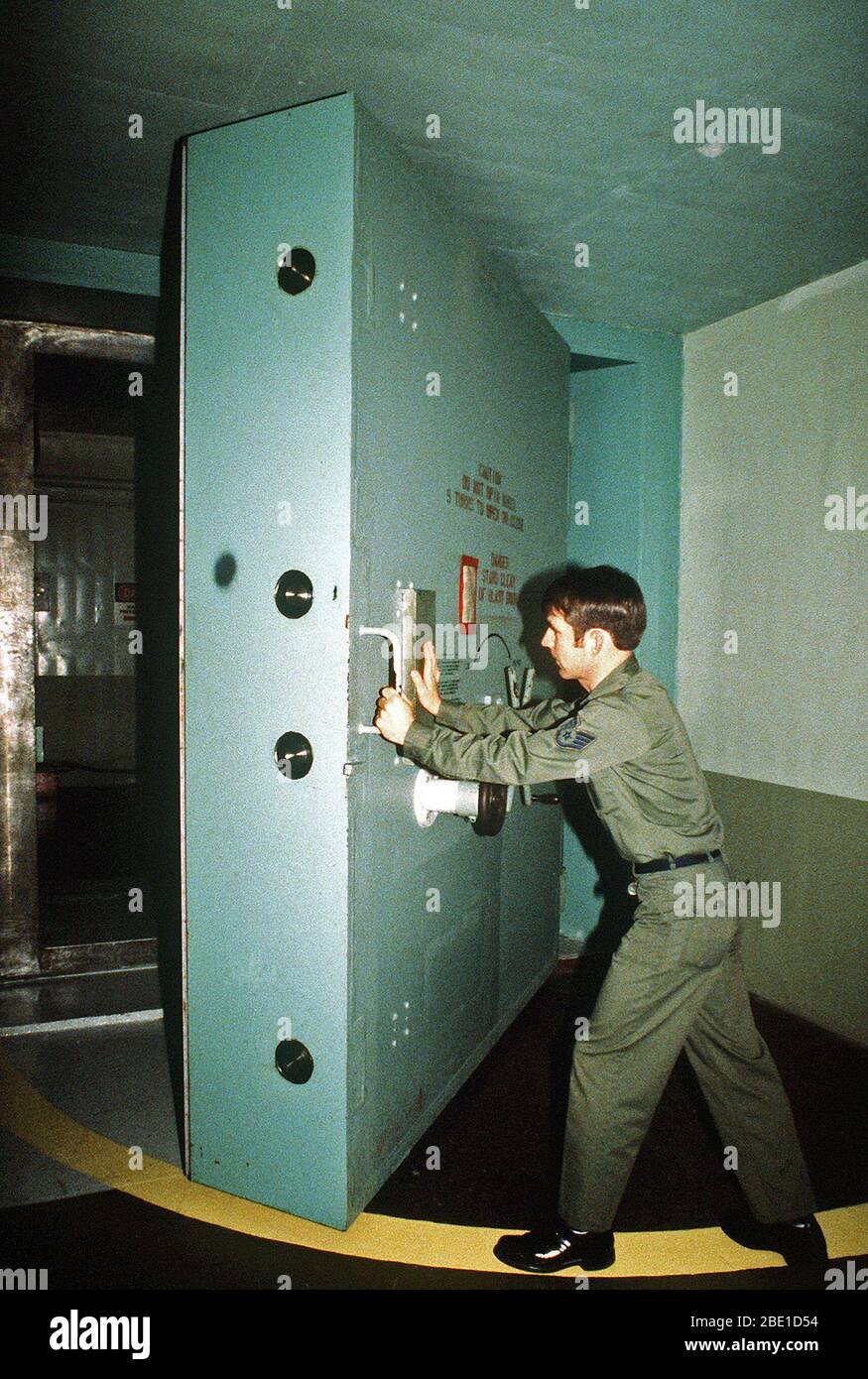 1981 - Personale Sgt. David Pierce manovre l'enorme di acciaio porta di accesso sotterranea di un missile launch control facility. Pierce è un manager della struttura, 91Missile strategico ala, Strategic Air Command. Foto Stock