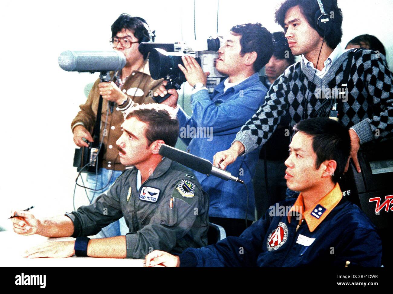 Un giapponese di televisione nazionale documenti crew briefing di U.S. Air Force e il giapponese Air Self Defense Force piloti durante l'esercizio a far fronte nord '80. Un U.S. Air Force F-4E Phantom II pilota aeromobili assegnati al 3° Tactical Fighter Wing è a sinistra. Foto Stock