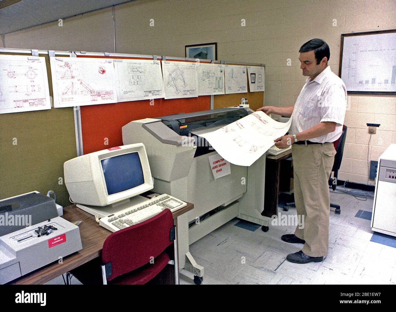 Un ingegnere controlla una stampa come egli utilizza il Computer Aided Design (CAD) sistema per sviluppare il sistema di montaggio per la sezione di coda del B-1 bombardiere. Foto Stock