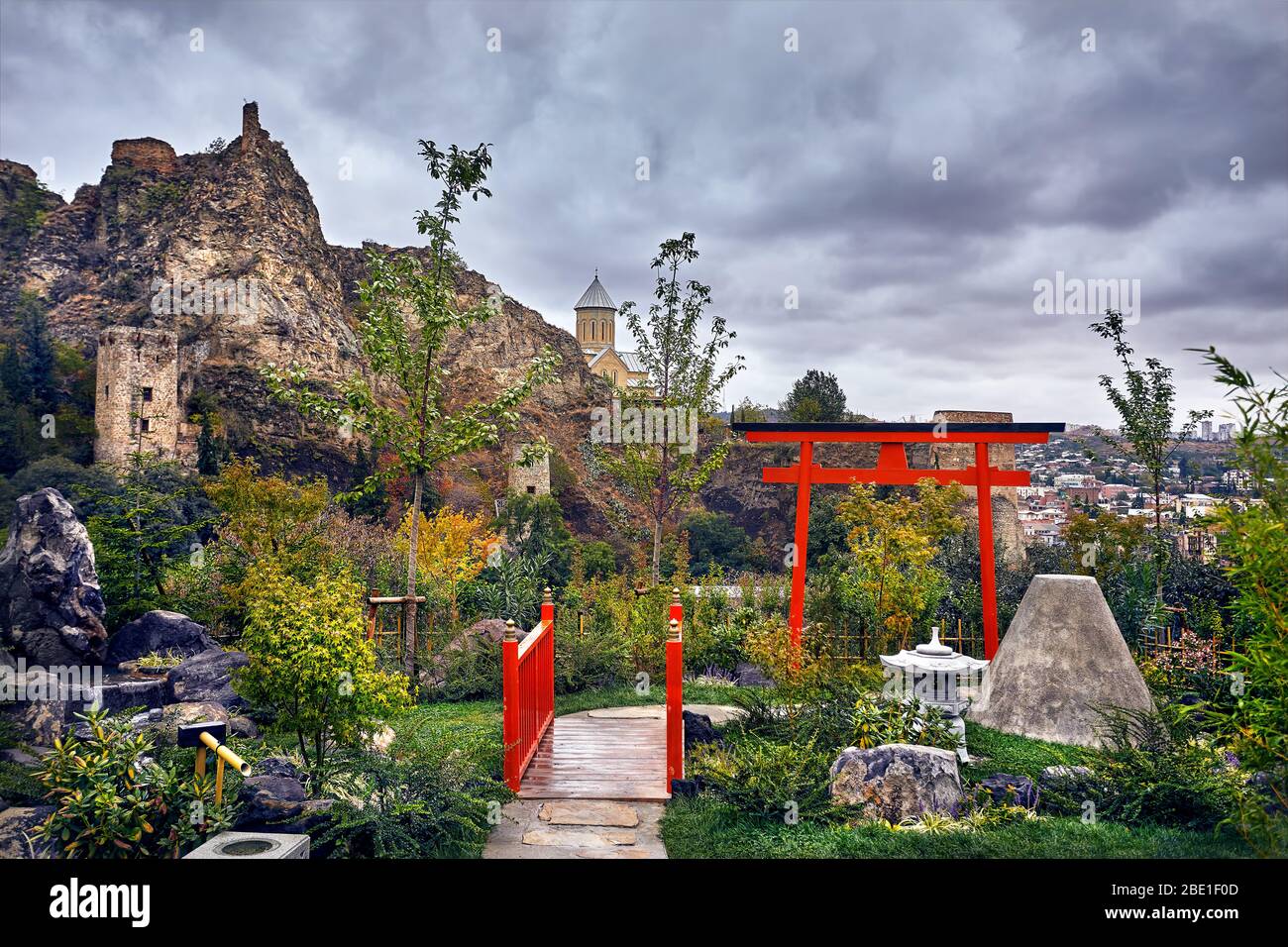 Giardino giapponese e il vecchio castello di Narikala a nuvoloso cielo nuvoloso nel giardino botanico di Tbilisi, Georgia Foto Stock