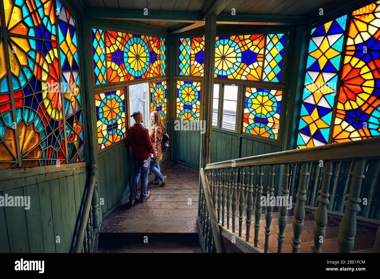 Coppia romantica di turista a balcone con scale e colorato mosaico bicchieri in Vecchia Tbilisi, Georgia. Foto Stock