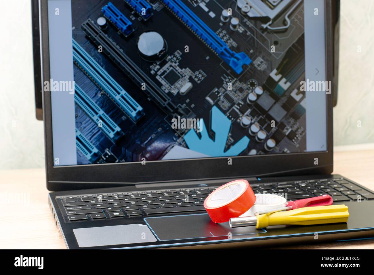 Concetto di lavoro remoto su Internet su un laptop Lie elettrico cacciavite a nastro su un laptop immagine schermo di un quadro elettrico Foto Stock