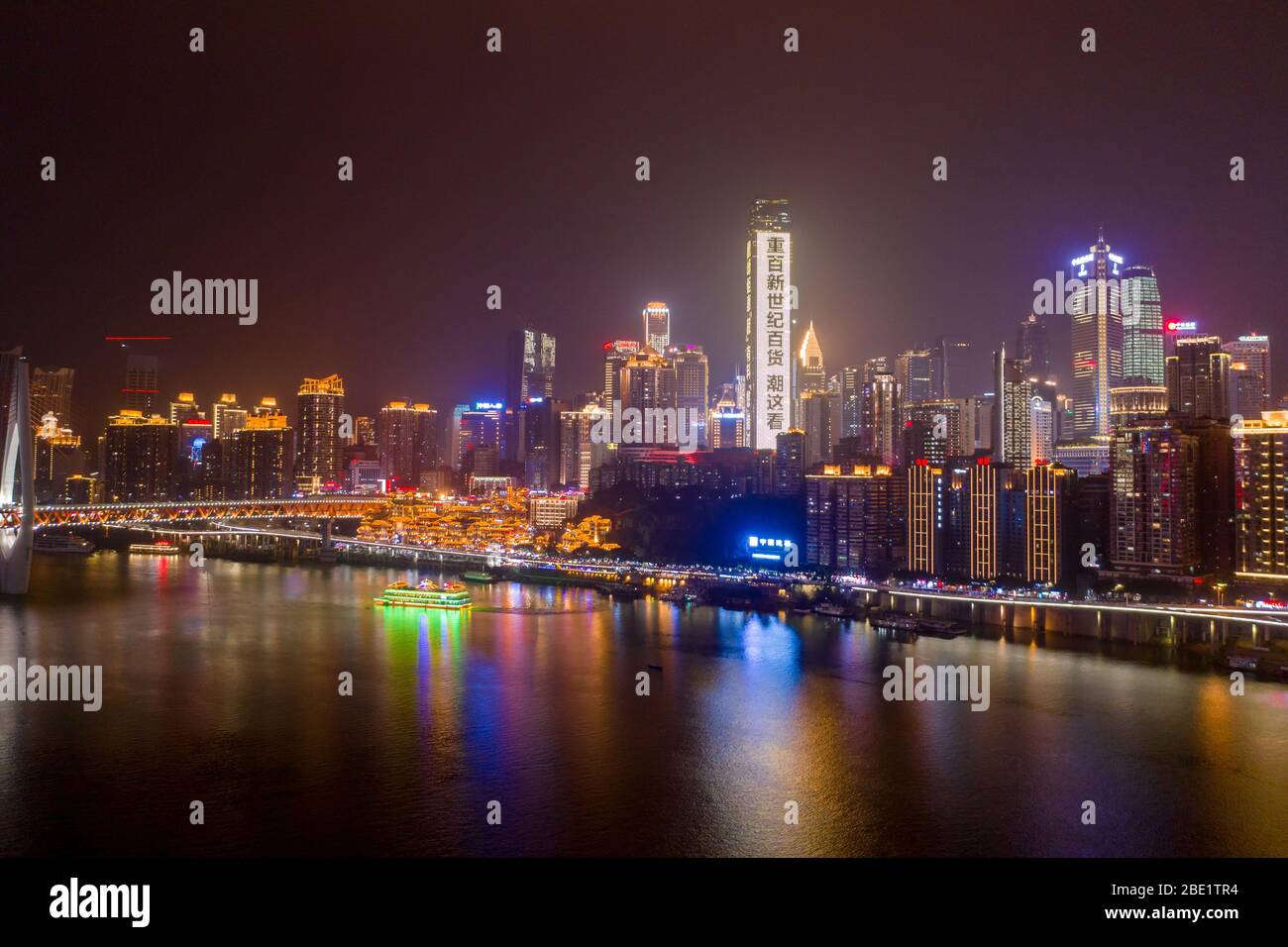 Chongqing, Cina - 22 dicembre 2019: Vista aerea della caverna di Hong Ya dong, storica città di religione popolare Cinese dal fiume Jialing con grattacieli illuminati Foto Stock