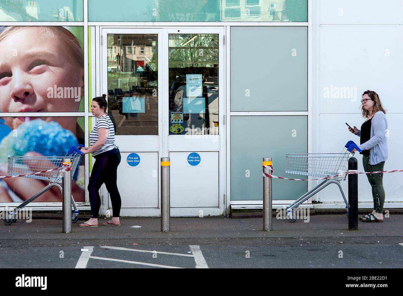 Brighton e Hove, Inghilterra, aprile 2020. Sulla scia della pandemia di coronavirus due donne mantengono una distanza sociale mentre fanno shopping in un supermercato. Foto Stock