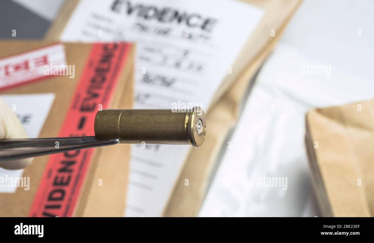 Laboratorio Criminalistic, scientifico ufficiale di polizia detiene bullet suggerimenti con pinzette per analisi balistica, immagine concettuale Foto Stock