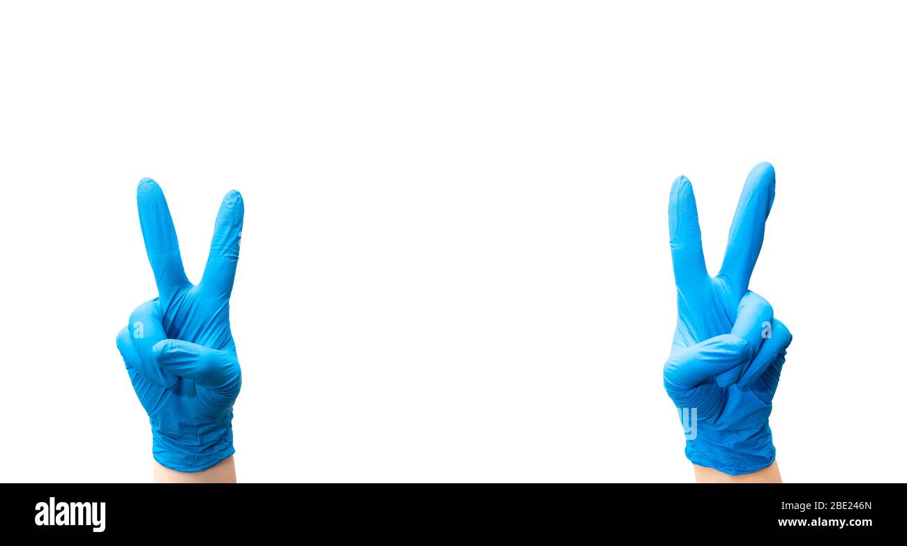 Mani di un medico con guanti che fanno segno di vittoria. Concetto di guarigione. Foto Stock