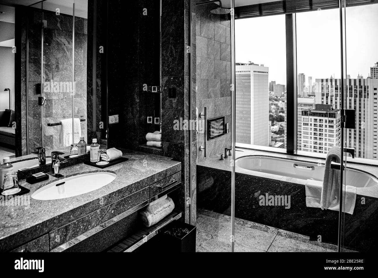 Il bagno del The Okura Tokyo, nel quartiere di Minato, Giappone, offre una vista sui tetti della città di milioni di abitanti attraverso una finestra dal pavimento al soffitto, ben al di sopra della folla della metropoli. Foto Stock