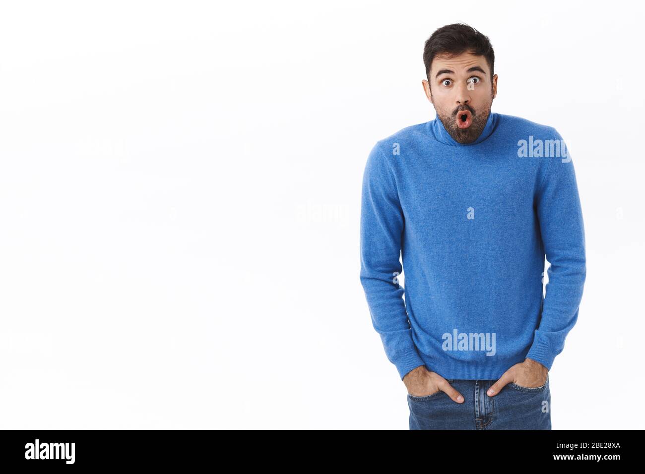Ritratto di scioccato e stupito, startled bell'uomo con barba, schioccando gli occhi alla macchina fotografica, bocca aperta speechless fissare macchina fotografica a qualcosa Foto Stock