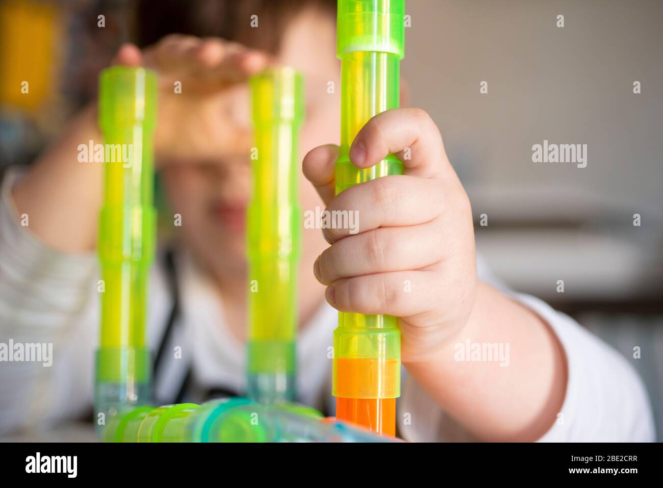 Giocare a Little Boy con tubi colorati Foto Stock