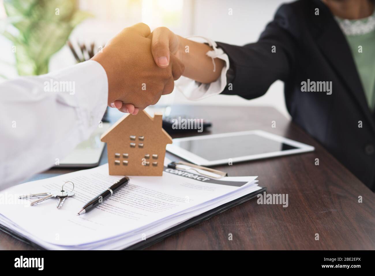 Mano scuotere di Agente immobiliare con il cliente dopo la firma del contratto in ufficio bancario, accordo di successo e concetto di contratto di acquisto casa Foto Stock