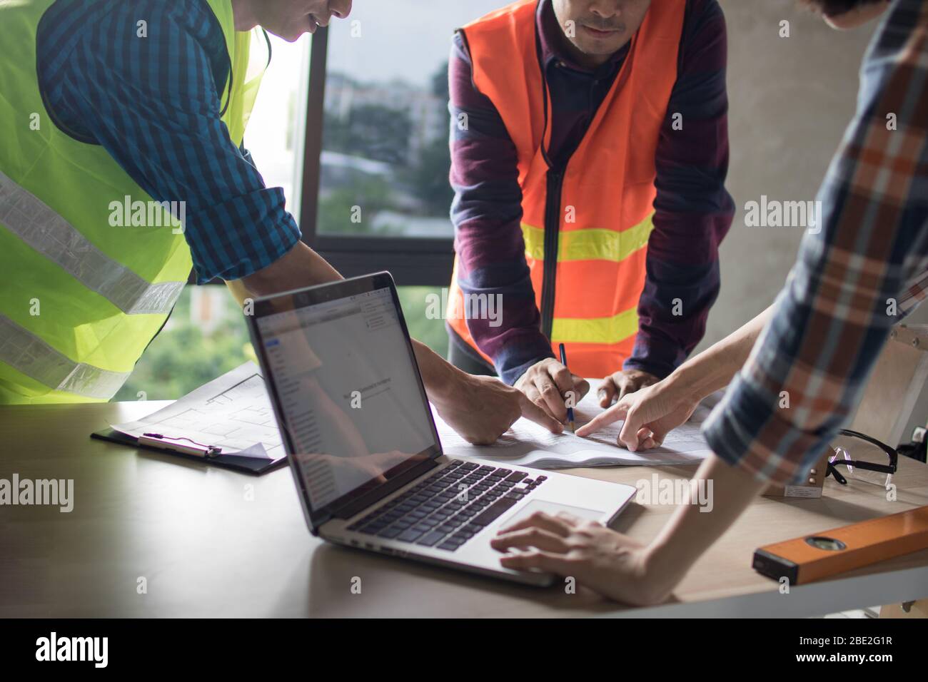 team di ingegneri che piangono e lavorano con notebook e stampa blu sul tavolo di lavoro nel cantiere Foto Stock