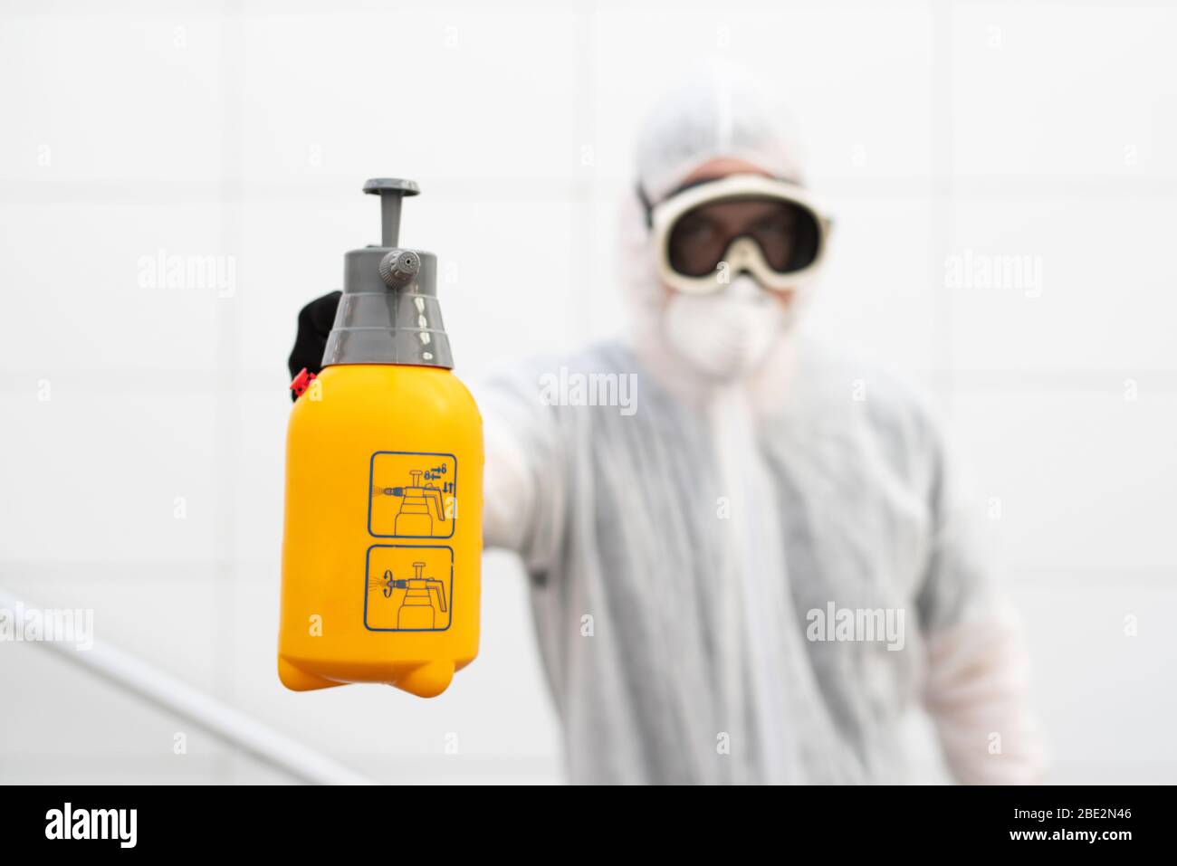 Un uomo disinfetta gli spazi pubblici al momento della crisi della corona Foto Stock