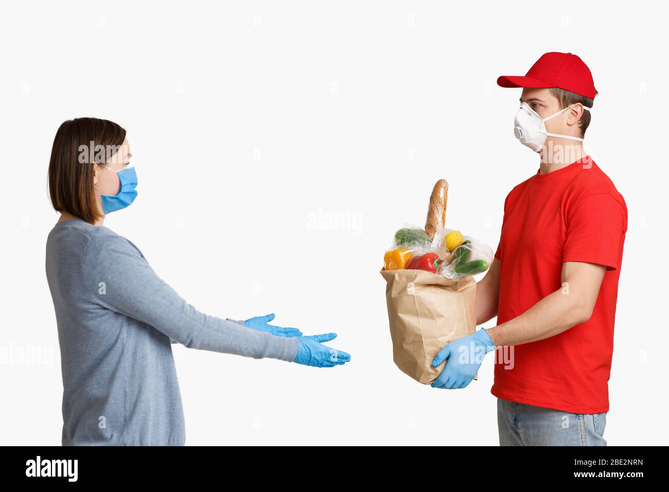 Il corriere consegna il cibo alla donna durante la quarantena Foto Stock
