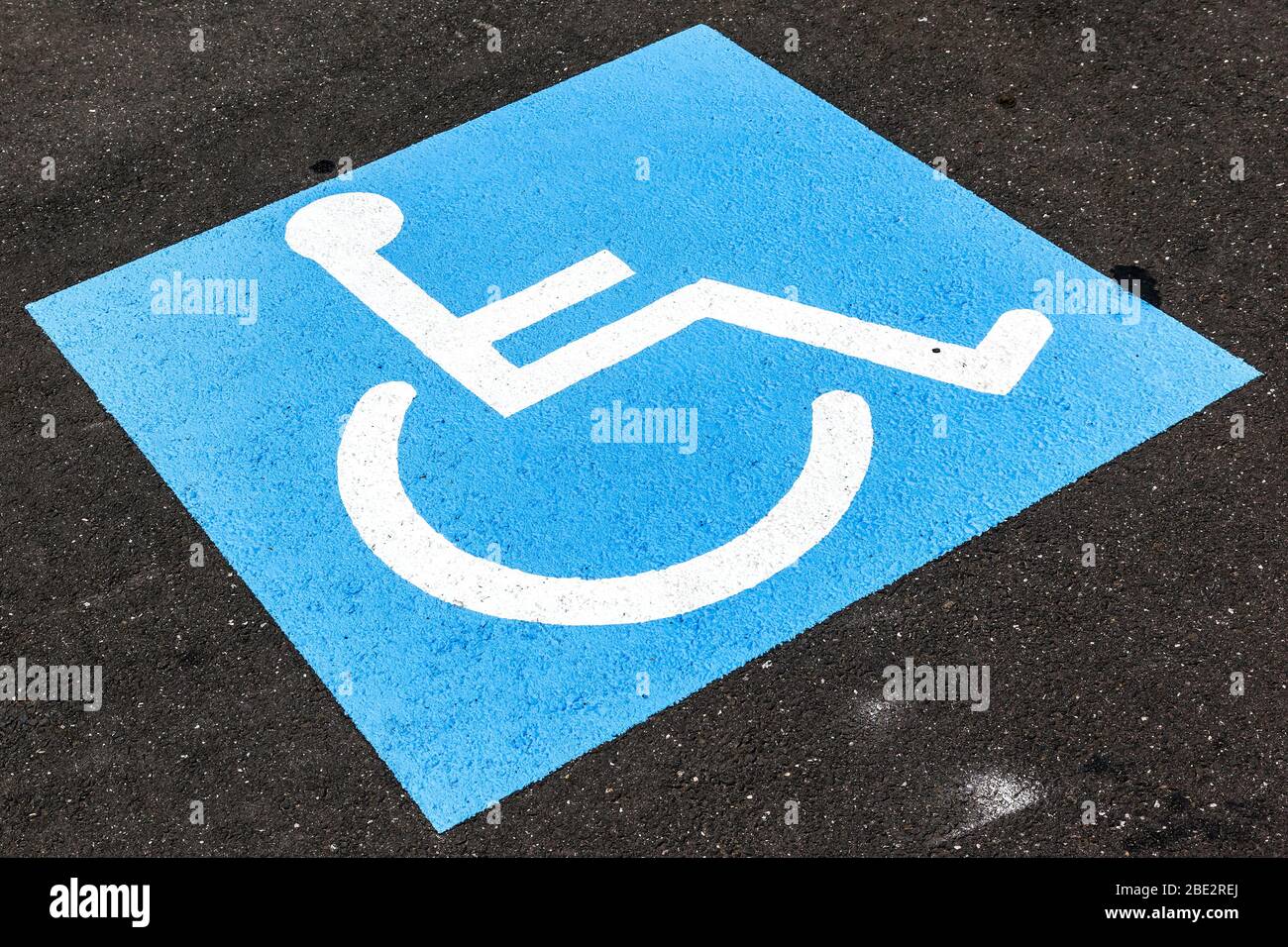 Ein Behindertenzeichen auf grauem asfalto Foto Stock