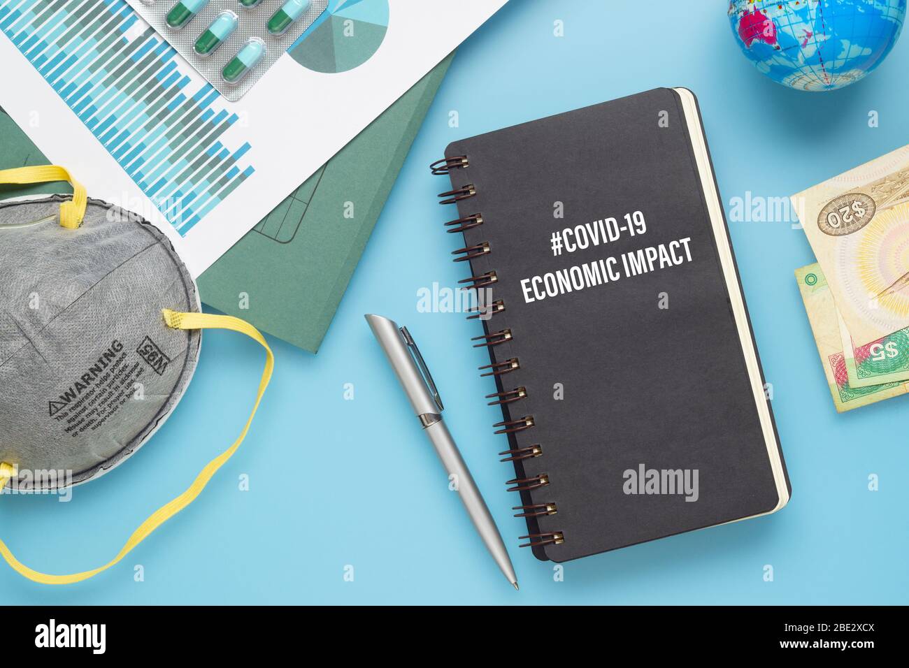 COVID-19 o concetto di background DI IMPATTO economico del virus Corona. Mockup notebook per Covid 19 Anlisi economica con busine schede grafiche, N95 faci Foto Stock