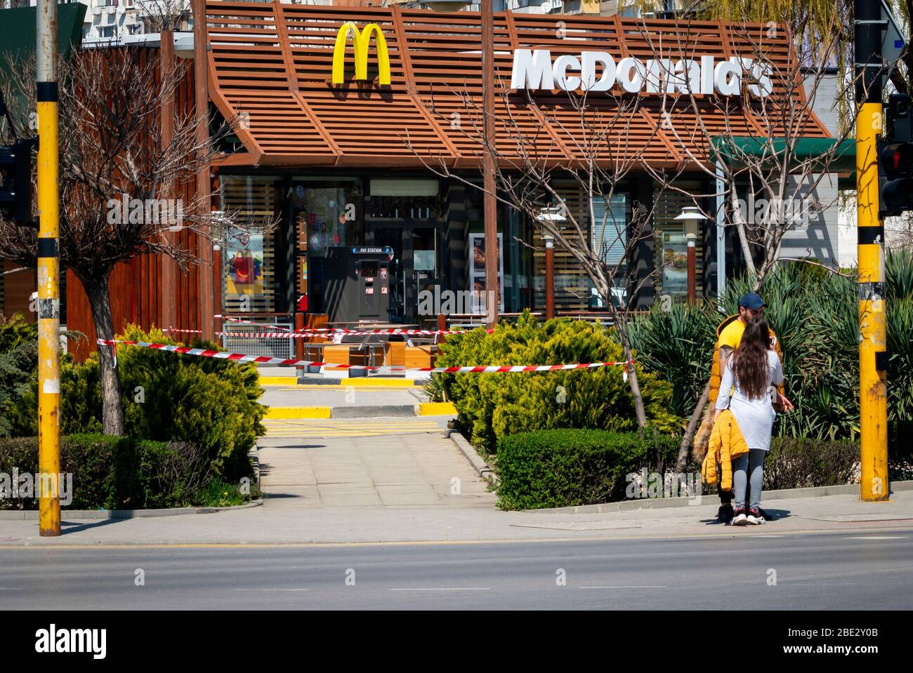 Persone in piedi di fronte a chiuso per il normale business McDonald's fast food che consente solo drive-in o drive-thru cibo da asporto a causa della diffusione del Coronavirus Pandemic di Covid-19 a Sofia, Bulgaria come 2020 Foto Stock