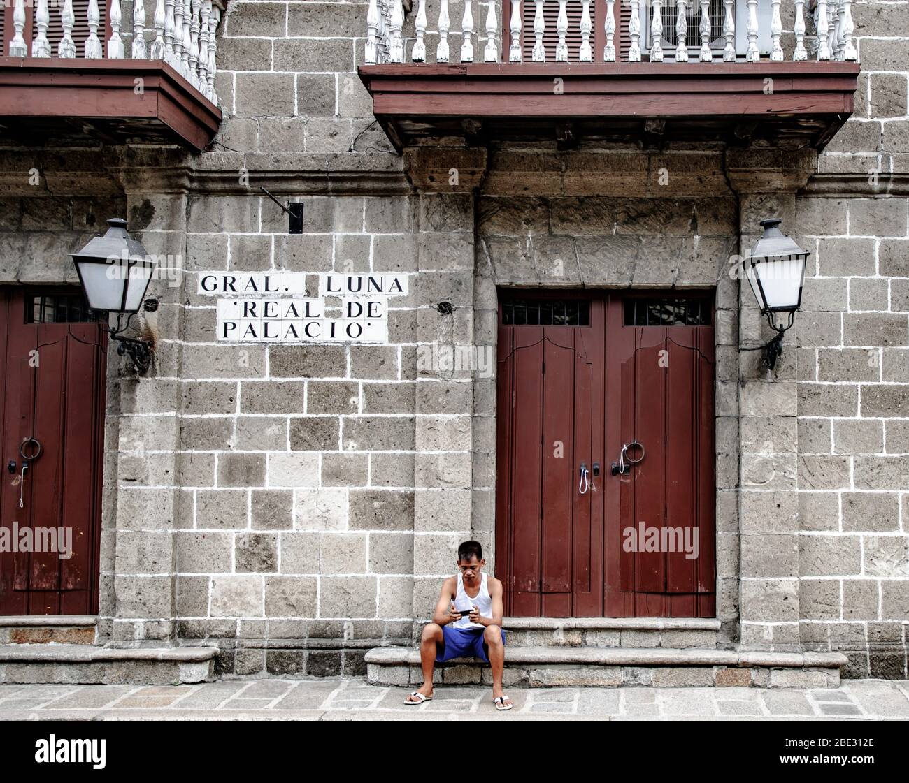 filippino locale seduto di fronte ad una casa coloniale a Intramuros, Manila, Filippine Foto Stock