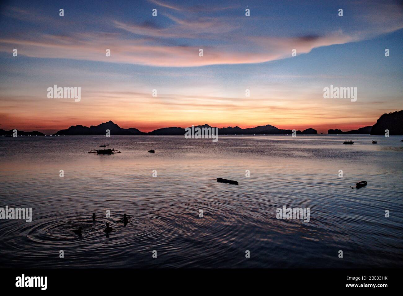 Persone che si rilassano al tramonto dopo una lunga giornata nel mare di El Nido Foto Stock