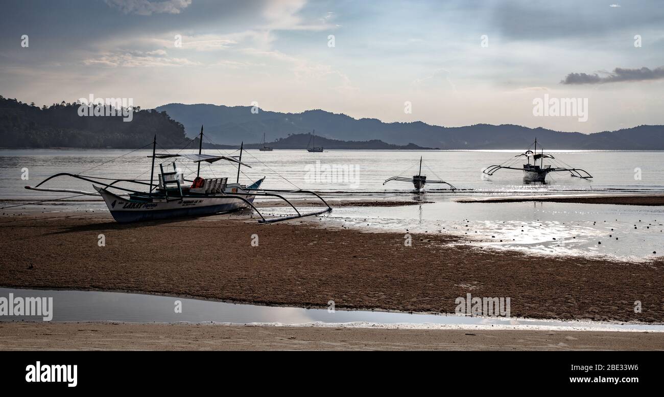 Barche a trefoli sulla spiaggia al tramonto Foto Stock