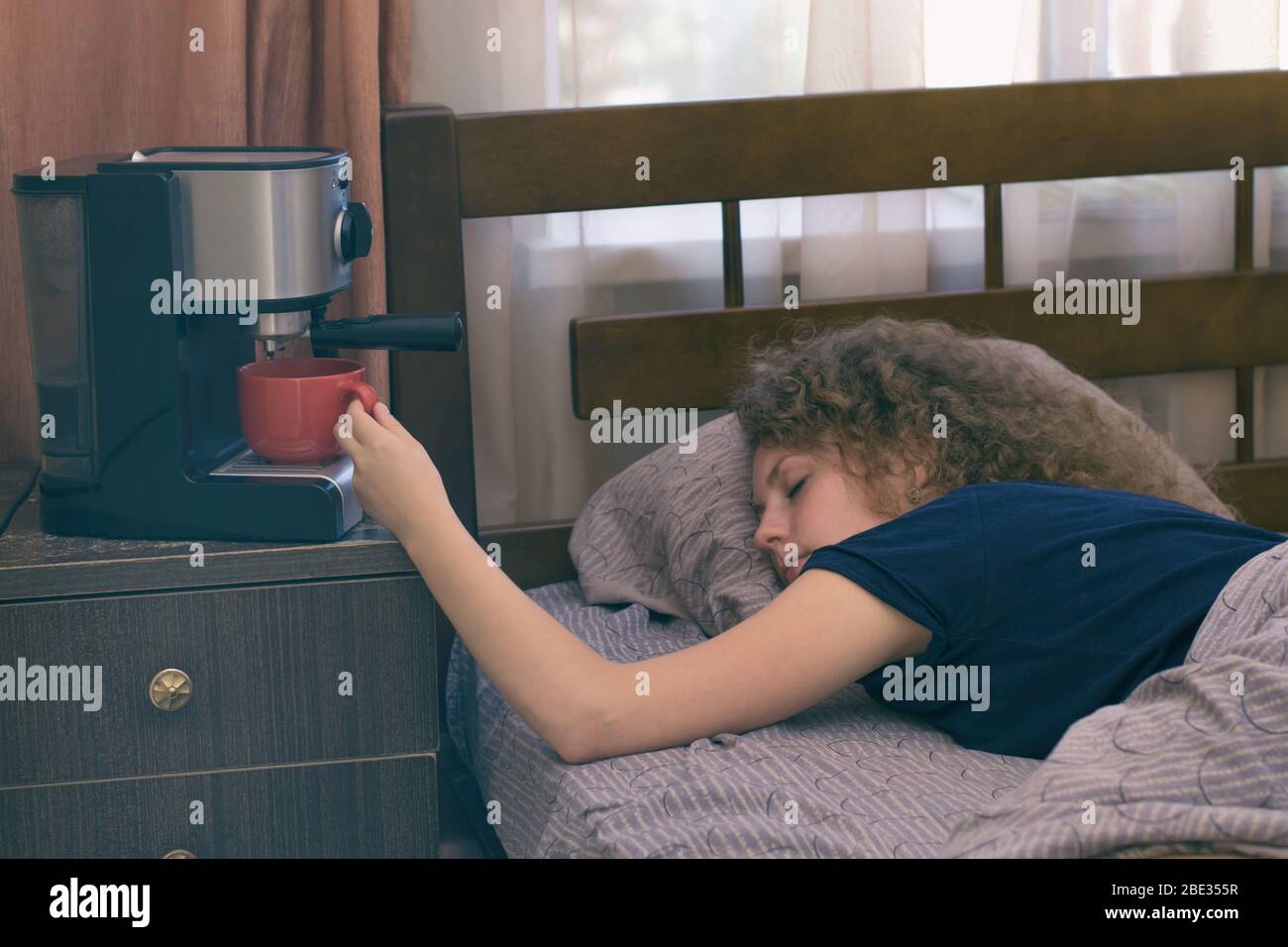 Una ragazza che non può svegliarsi senza una tazza di caffè Foto Stock