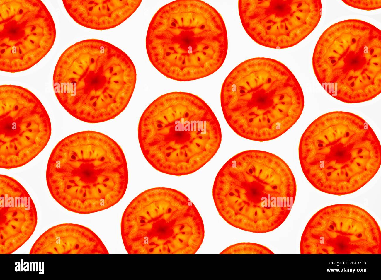 una bella immagine di un interessante dettaglio pattern di pachino tomatoe fettine su uno sfondo bianco brillante, flatlay Foto Stock