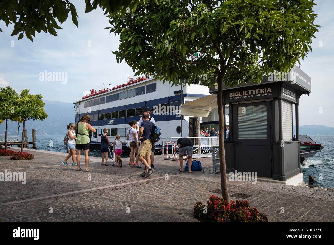 I passeggeri attendono di salire a bordo di un traghetto a Gargnano sulle rive del Lago di Garda. Foto Stock