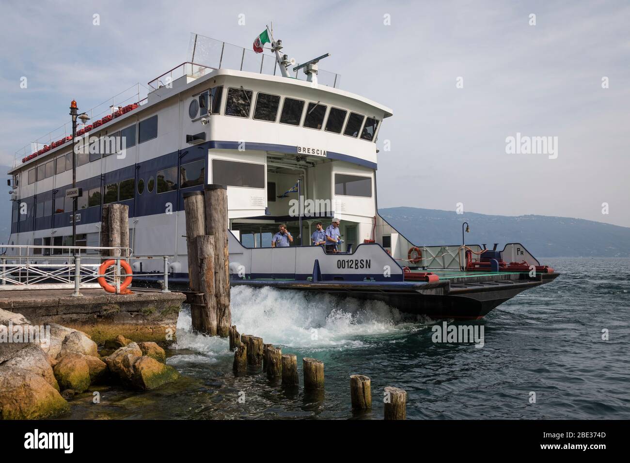 Un traghetto parte dal piccolo molo di Gargnano sulle rive del Lago di Garda. Foto Stock
