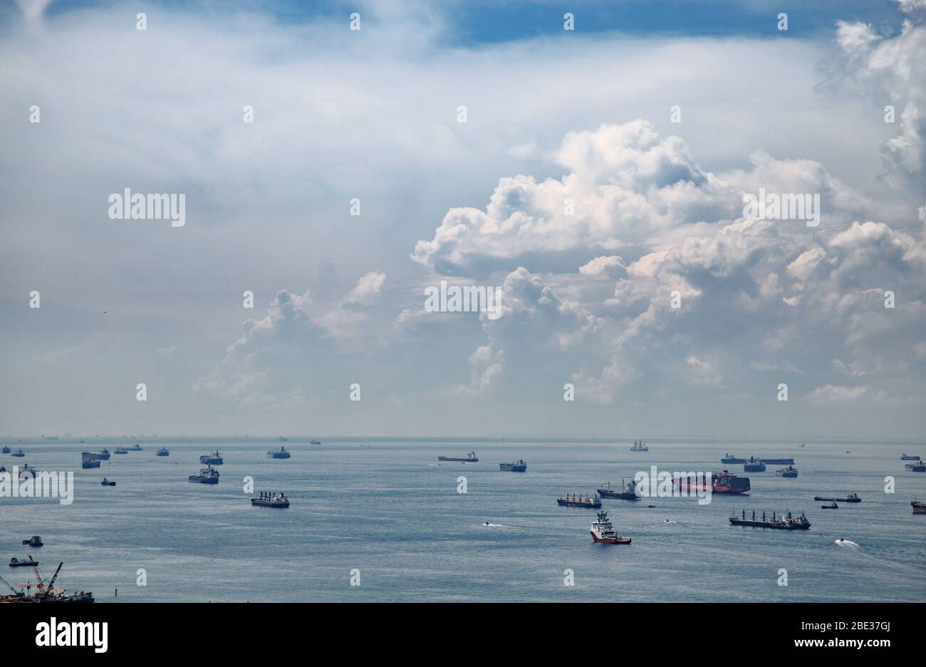 Diverse navi ancorate in attesa all'esterno per l'ingresso nel porto di singapore - Distintos barcos anclados a la espera de la entrada en el puerto de Singapur Foto Stock