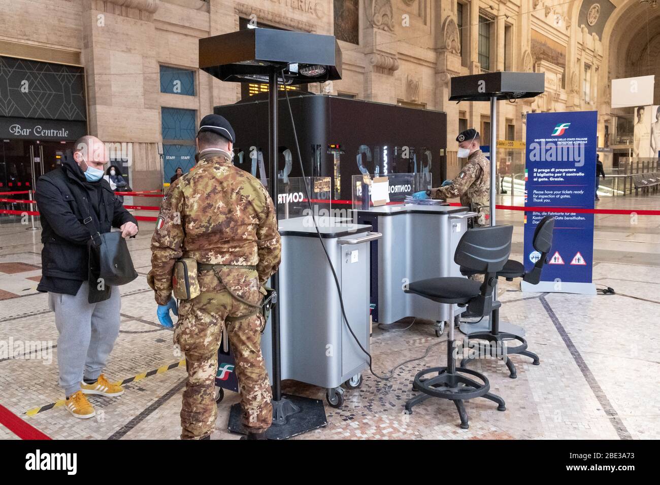 Stazione centrale di Milano al momento del coronavirus. La polizia controlla i passeggeri prima di accedere alle piattaforme ferroviarie. Marzo 16,2020 Foto Stock