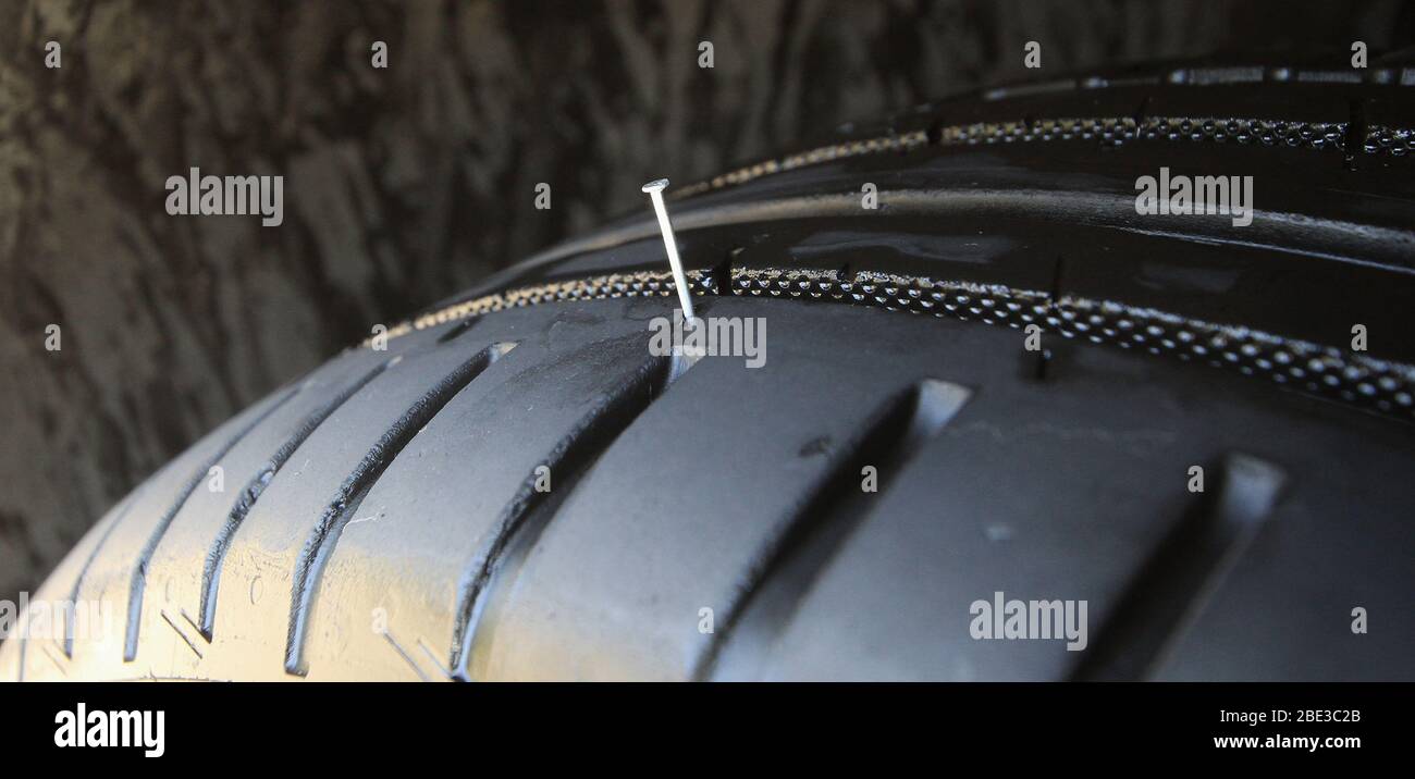 Chiodo di ferro bloccato dallo pneumatico del veicolo Foto Stock