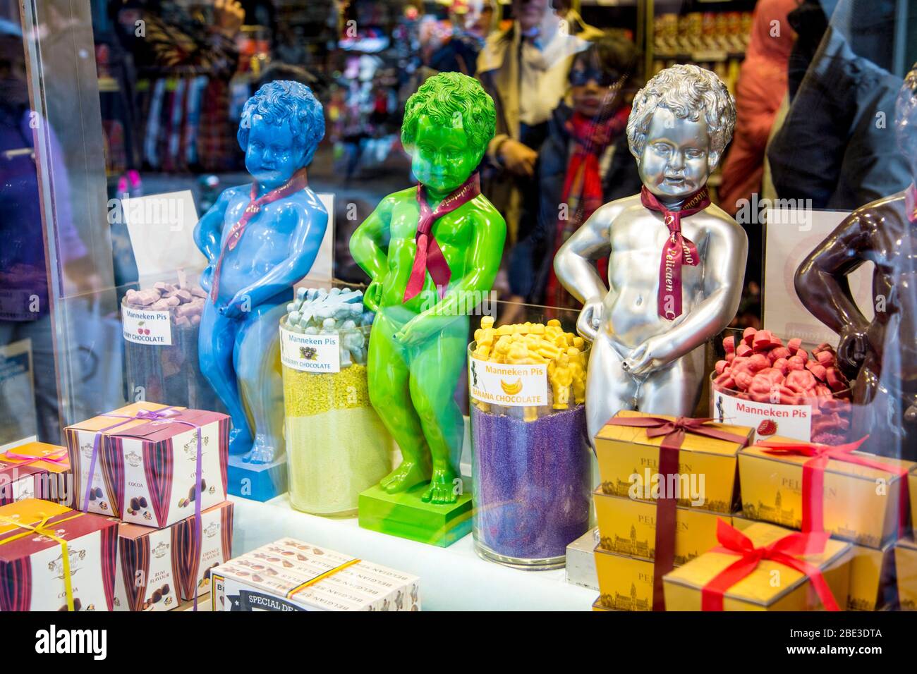 Riproduzioni colorate della scultura del Manneken Pis in una vetrina di negozi di dolci, Bruxelles, Belgio Foto Stock