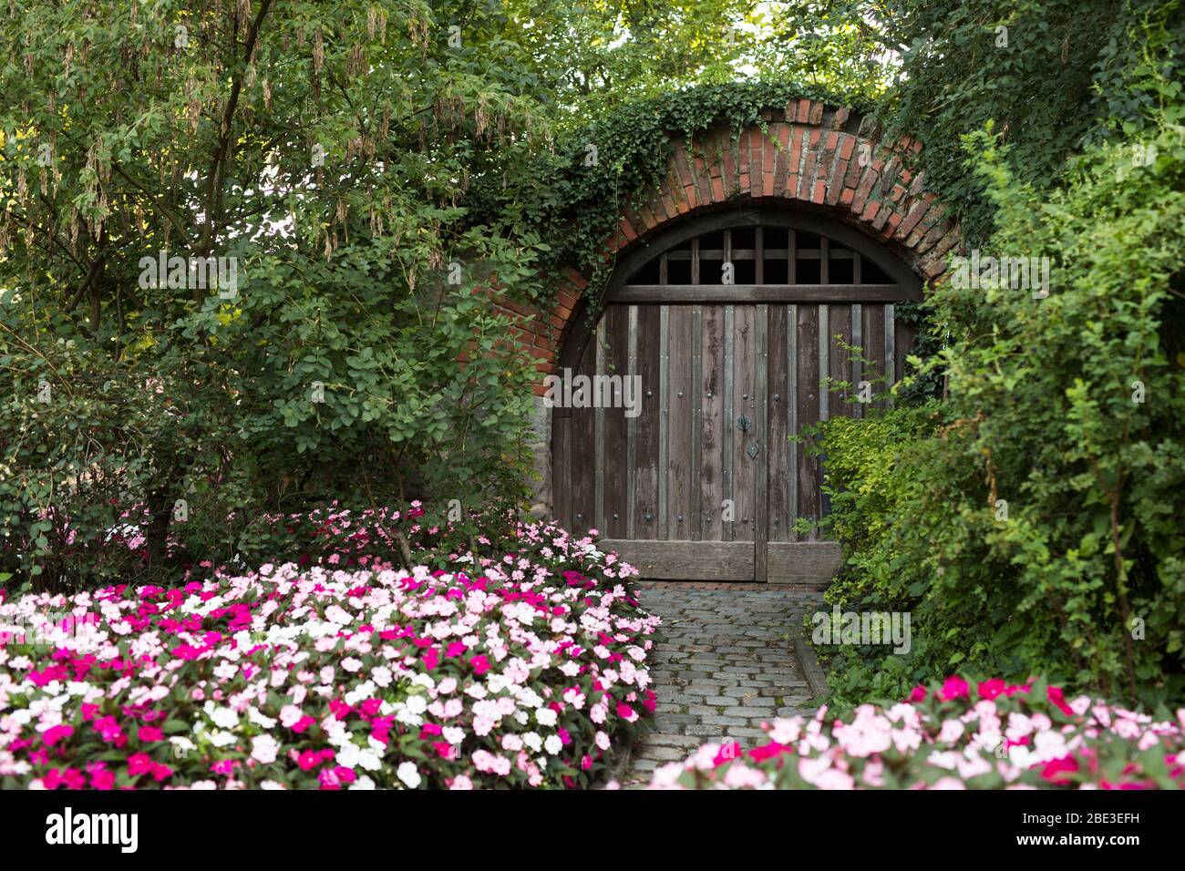 Una porta ad arco circondata da fiori al Castello Imperiale di Norimberga, Germania. Foto Stock