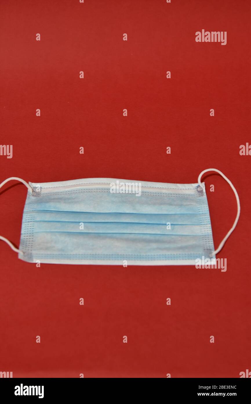 Maschera protettiva medica su sfondo rosso. Concetto di assistenza sanitaria Foto Stock