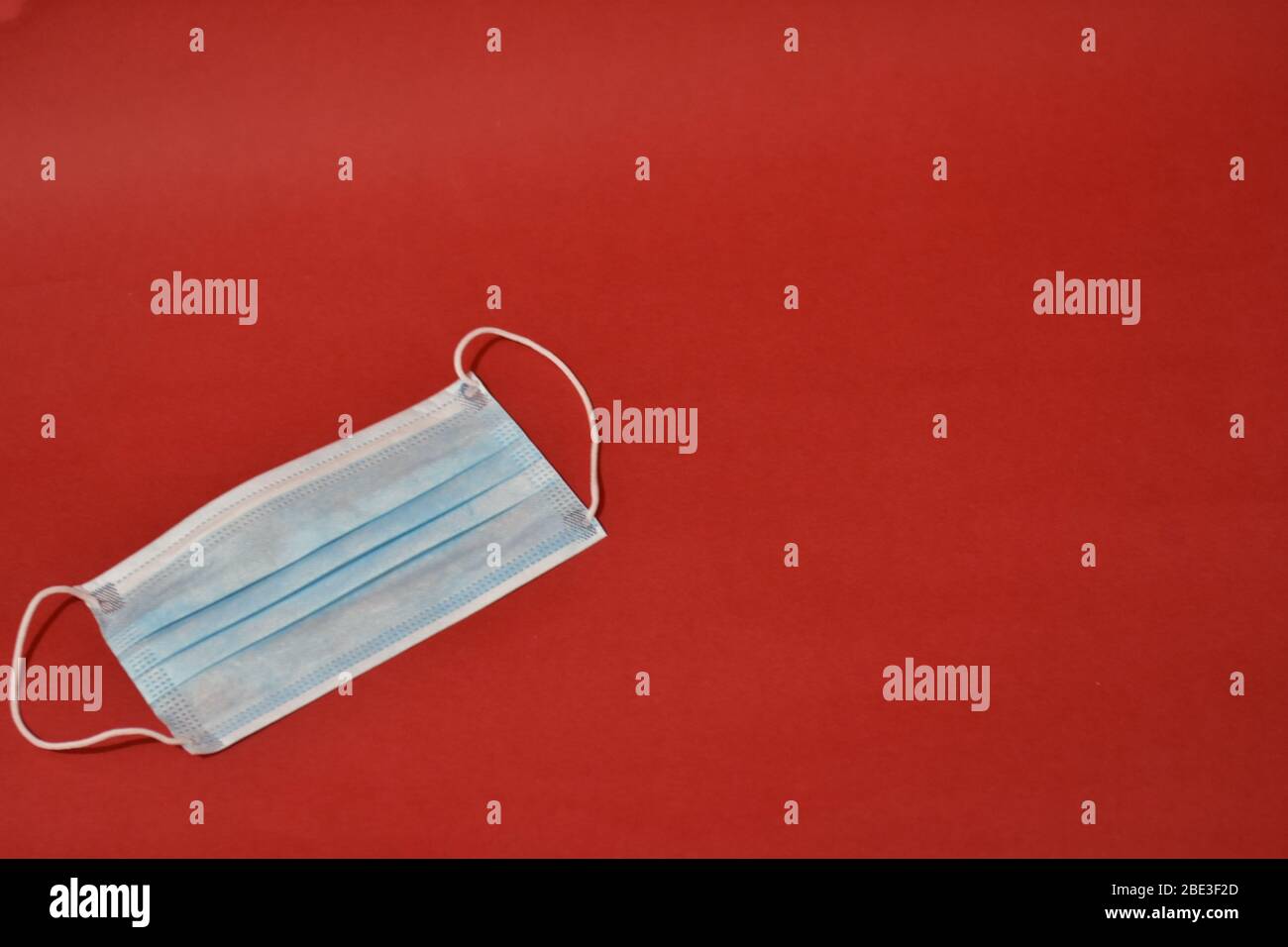 Maschera protettiva medica su sfondo rosso. Concetto di assistenza sanitaria Foto Stock