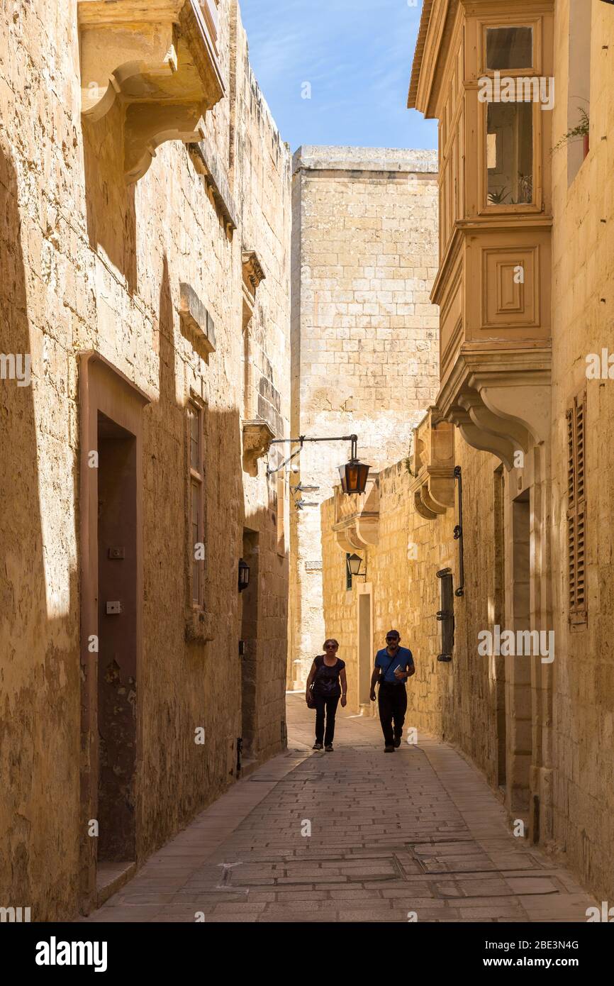 Due persone che camminano attraverso la Città silenziosa di Mdina, Malta Foto Stock