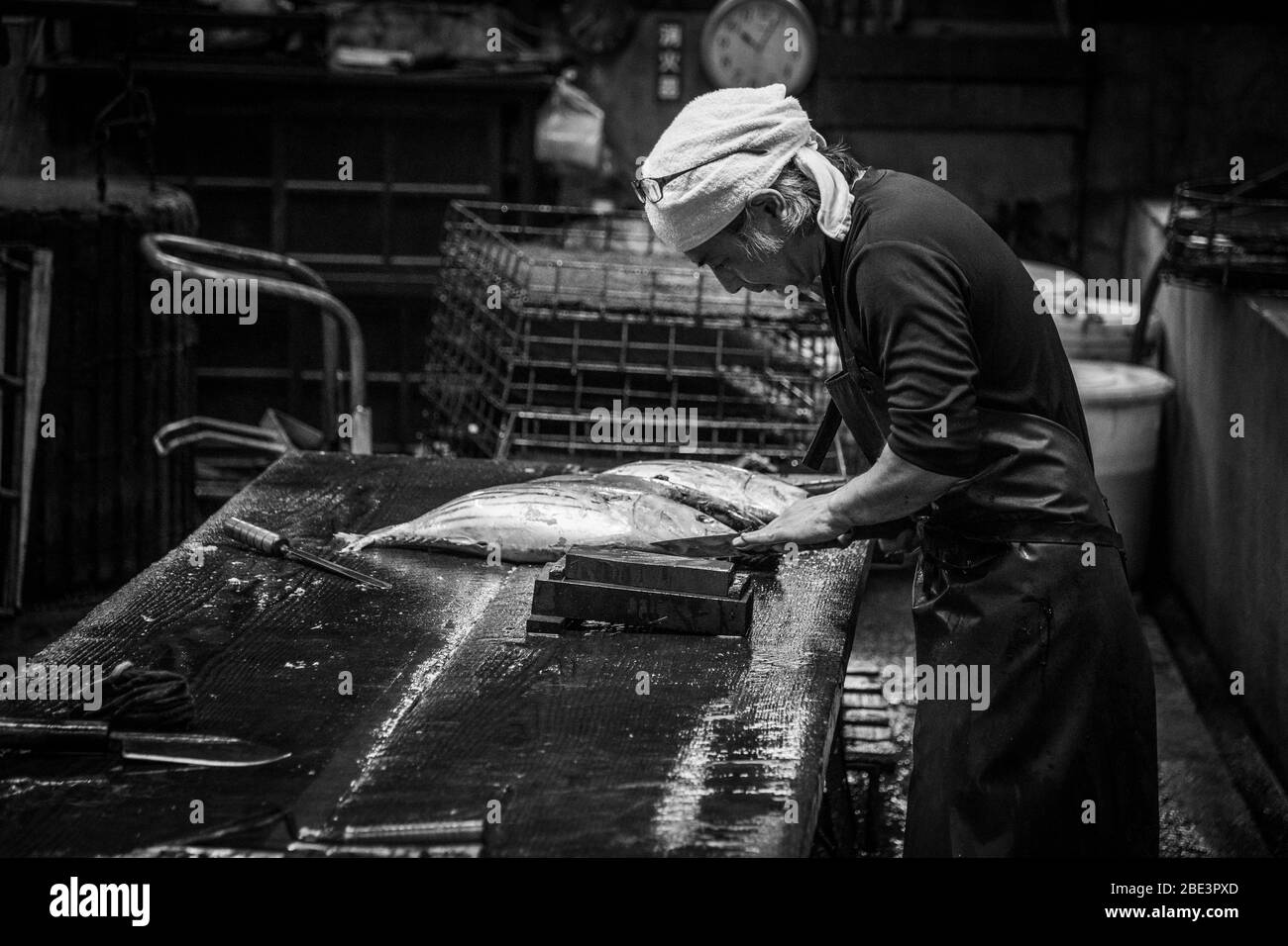 Yasuhisa Serizawa si china sul tavolo di legno per filettare un bonito per la produzione di katsuobushi, nella sua manifattura Kanesa, Nishiizu-Cho, prefettura di Shizuoka, Giappone. Foto Stock