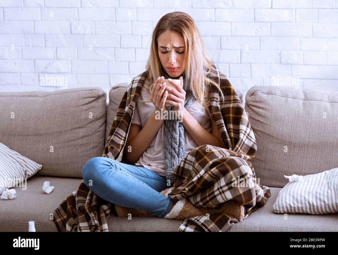 Ragazza in plaid sta bevendo il tè caldo Foto Stock