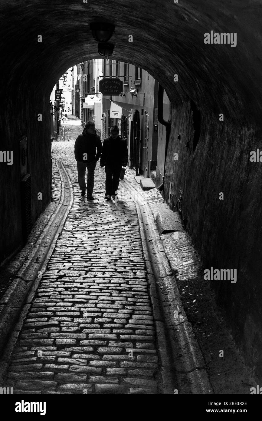 Coppia su ciottoli sotto la vecchia archway nella città vecchia di Stockholms. Foto Stock