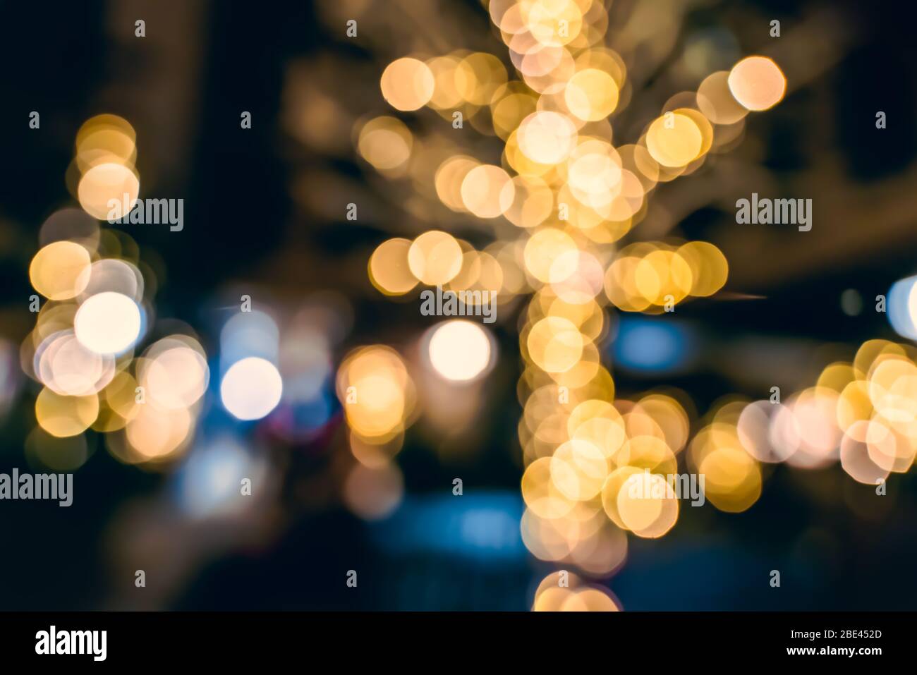 Bokeh di luci festive calde intorno agli alberi durante la stagione di Natale, Londra Regno Unito Foto Stock