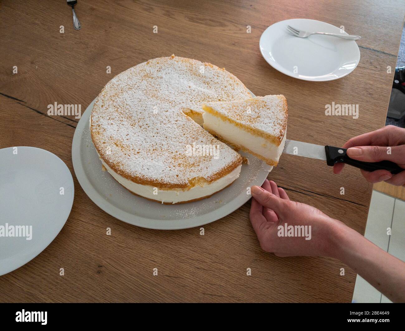 Taglio di una cheesecake cremosa, self cotta da mia moglie. Foto Stock