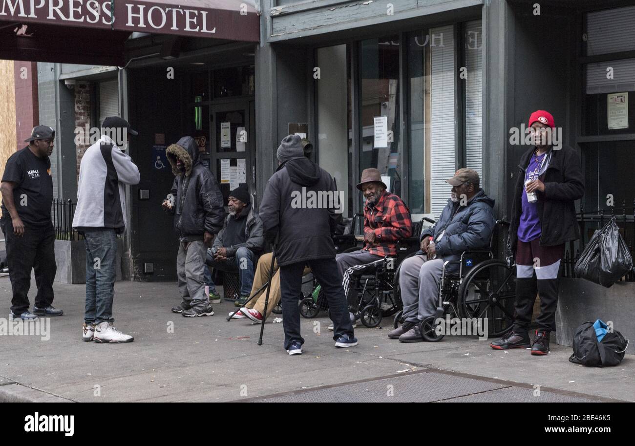 Hayward, Stati Uniti. 11 Aprile 2020. Gli uomini socializzano nel distretto di Tenderloin di San Francisco il sabato 11 aprile 2020. Le autorità stanno cercando luoghi per le migliaia di senzatetto della città per rifugiarsi durante la pandemia di coronavirus. Foto di Terry Schmitt/UPI Credit: UPI/Alamy Live News Foto Stock