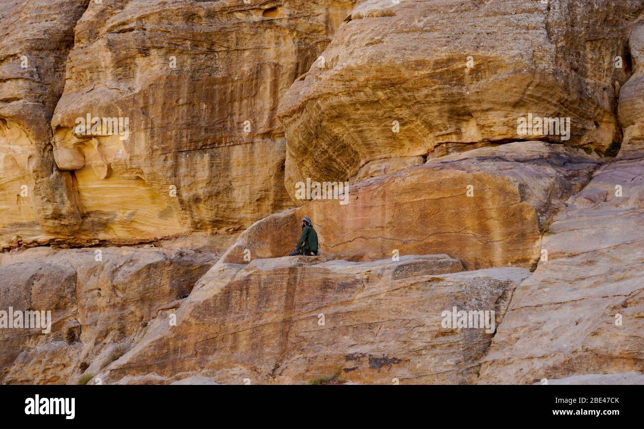 Jordan, Wadi Musa, l'uomo beduino sta pregando sulla roccia. Foto Stock