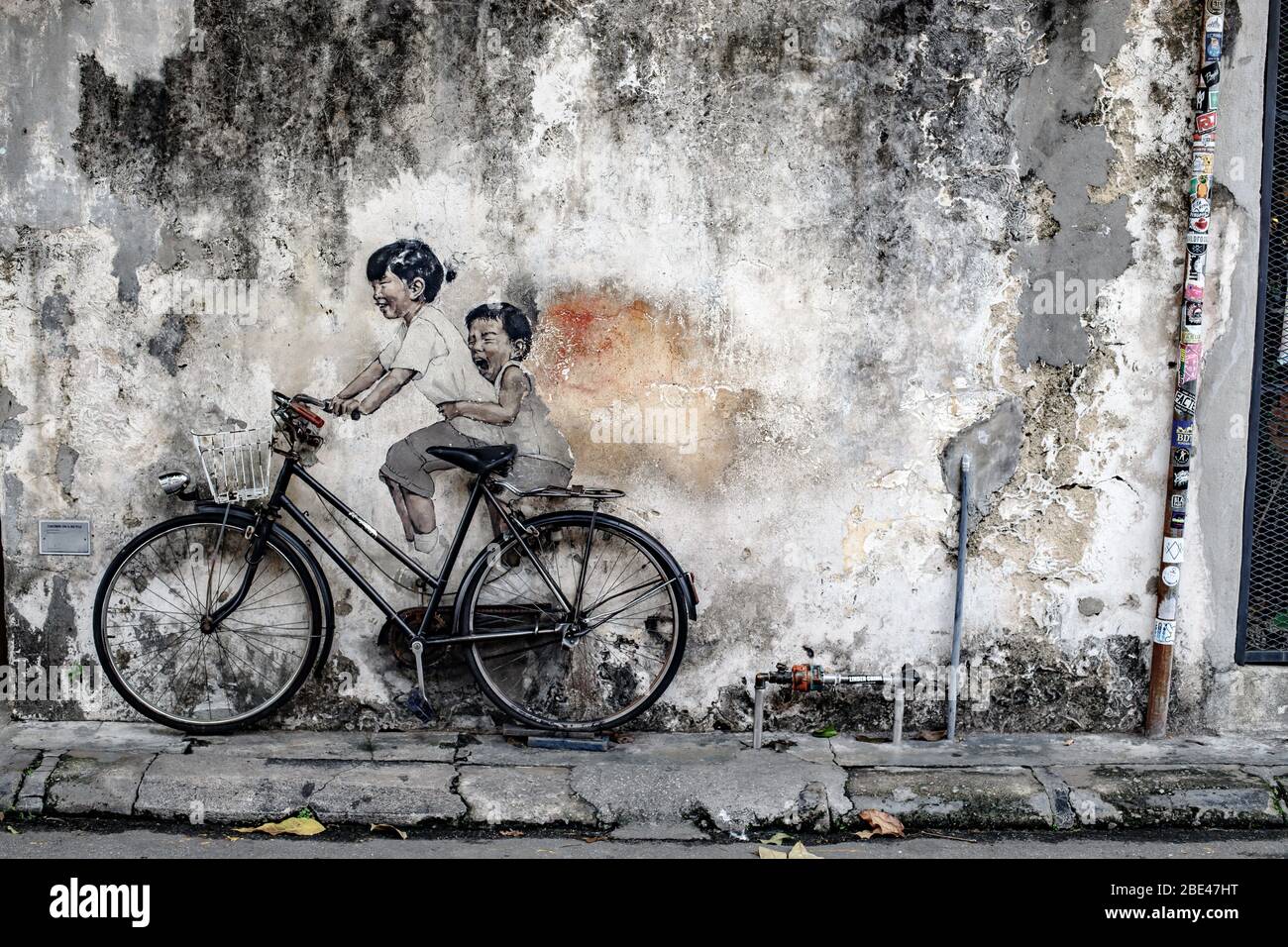 Opere d'arte di strada di due bambini in bicicletta a Penang, Malesia - Arte urbano de dos niños montando una bicicleta en Malasia Foto Stock