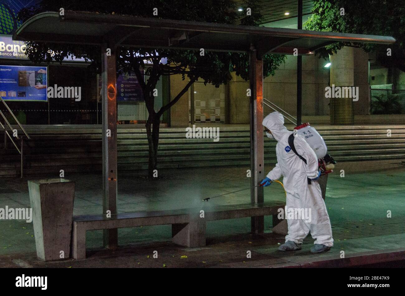 Il personale addetto alla pulizia a piedi disinfetta una piazza e strade. Giorno della notte pulizia e disinfezione nelle strade di Caracas, Venezuela, per prevenire il spr Foto Stock